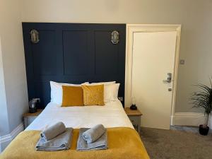 a bedroom with a large bed with two towels on it at Victorian Suites in Southport