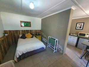 a small bedroom with a bed and a kitchen at ROCKABILLY RANCH Self-Catering Guest Units in Pietermaritzburg