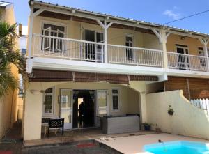 a large house with a balcony and a swimming pool at Villa Soleil in Mont Choisy
