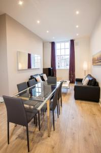 uma sala de estar com uma mesa de vidro e cadeiras em Temple Bar Essex Apartments em Dublin