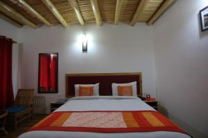 a bedroom with a bed and a red curtain at Hotel Lhalingkha in Leh