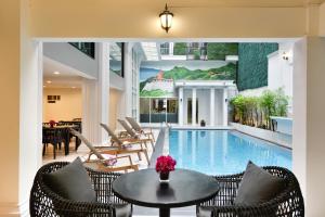 a pool room with a table and chairs and a table sidx sidx at Villa De Pranakorn in Bangkok