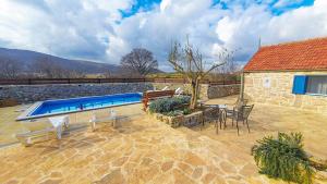 a patio with a swimming pool and a table and chairs at Didini Dvori in Kruševo