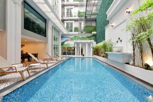 a pool in a building with chairs and plants at Villa De Pranakorn in Bangkok
