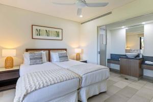 a bedroom with a large bed and a bathroom at Bellflower at Temple - Family Beachside Paradise in Palm Cove