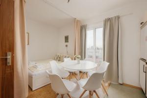 une salle à manger blanche avec une table et des chaises blanches dans l'établissement Apartment ZENTRAL direkt an U-BAHN STATION, à Vienne