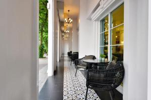 a hallway with a table and chairs on a tile floor at Villa De Pranakorn in Bangkok
