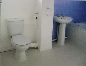 La salle de bains est pourvue de toilettes et d'un lavabo. dans l'établissement Spacious three bedroom property in Penrhyn bay - sleeps 6, à Penrhyn Bay
