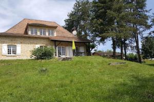 ein Haus auf einem grasbewachsenen Hügel in der Unterkunft Grande maison quercynoise avec piscine in Figeac