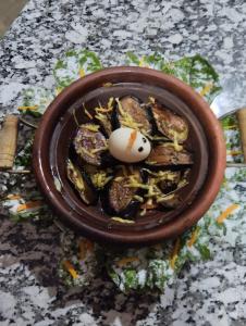 a bowl of food with a egg on top at Riad Akabar Merzouga in Merzouga