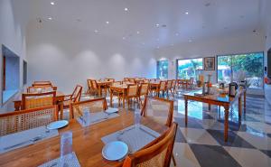a dining room with wooden tables and chairs at Aranya Vilas, Ranthambhore in Khilchipur