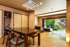 Beautiful Japanese Garden Kagetsu في Fuefuki: غرفة طعام مع طاولة وكراسي خشبية