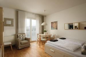 een slaapkamer met een bed, een tafel en een stoel bij Modern Vienna Apartment in Prime Location in Wenen
