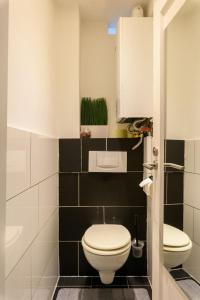 a bathroom with a white toilet and black tiles at Modern Vienna Apartment in Prime Location in Vienna