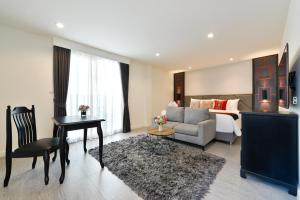 a living room with a couch and a bed at Villa De Pranakorn in Bangkok