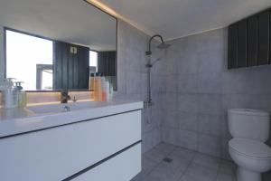 uma casa de banho com um WC, um lavatório e um espelho. em Spr Finca em Sauzal