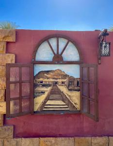 a mural on the side of a building with a window at Dream Lodge Siwa دريم لودج سيوة in Siwa