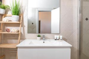 By Eezy- דירה משפחתית מפנקת 3 חדרי שינה - Hanechoshet في إيلات: حمام مع حوض أبيض ومرآة