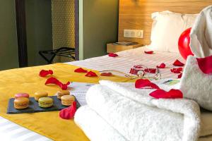 un lit avec des roses rouges et de la nourriture dans l'établissement Hôtel de France, un hôtel AMMI, à Nice