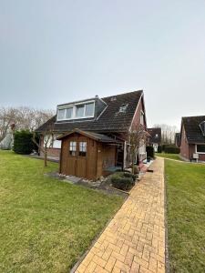 a house with a gambrel roof and a brick driveway at Beach Club Fehmarn 9249 in Fehmarn