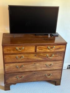 a television on top of a wooden dresser at Reynolds House in Faringdon