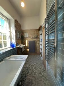 a bathroom with a tub and a sink at Reynolds House in Faringdon