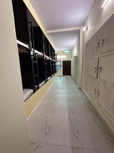 an empty hallway in a building with marble floors and windows at The Darsya Varanasi in Varanasi