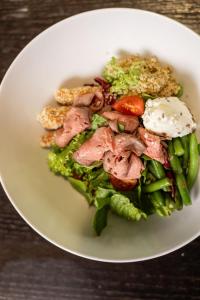 a white plate with a salad with meat and vegetables at IQ Hotel in Kyiv