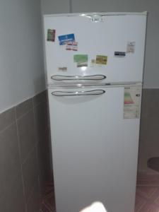 a white refrigerator in a kitchen with magnets on it at El rosal ,descanso para viajeros in Junín +19 photos