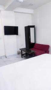 un soggiorno con divano rosso e specchio di Roomshala 161 Hotel Three Kings a Nuova Delhi