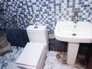 bagno con servizi igienici bianchi e lavandino di Roomshala 161 Hotel Three Kings a Nuova Delhi