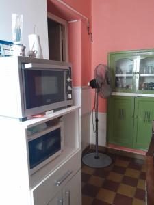 a kitchen with a microwave and a television on a counter at El rosal ,descanso para viajeros in Junín