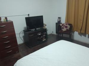 a bedroom with a bed and a tv and a dresser at El rosal ,descanso para viajeros in Junín