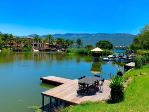 a dock with a table and chairs on a lake at Westlake Waterfront Villa - Entire Villa in Hartbeespoort