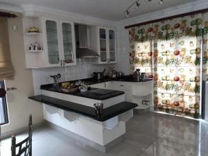 une cuisine avec des placards blancs et un comptoir noir dans l'établissement Westlake Waterfront Villa - Entire Villa, à Hartbeespoort