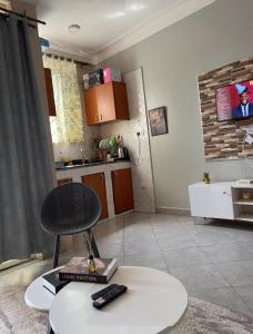 sala de estar con silla y cocina en Escape room, en Kampala