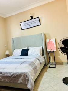 1 dormitorio con 1 cama y un cartel en la pared en Escape room, en Kampala