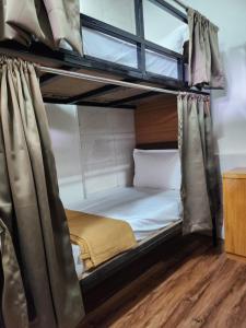 Habitación con 2 literas y cortinas. en Galaxy Cabin Stay And Dormitory, en Bombay