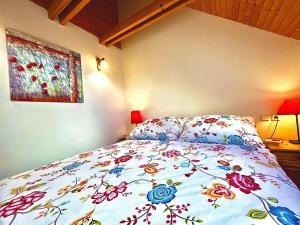 1 dormitorio con 1 cama con colcha de flores en Holiday Resort Švárny, en Ružomberok