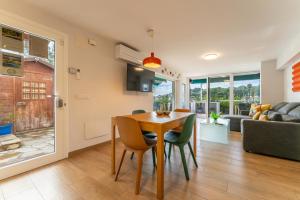 a dining room and living room with a table and chairs at Luxury Designer Beach Front Two Bedroom Apartment in Salou
