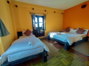 a room with two beds and a window at Bandipur Kaushi Inn in Bandīpur