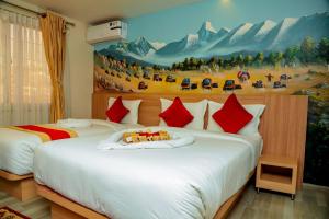 ein Schlafzimmer mit 2 Betten und einem Gemälde an der Wand in der Unterkunft Hotel Kedarnath in Kathmandu