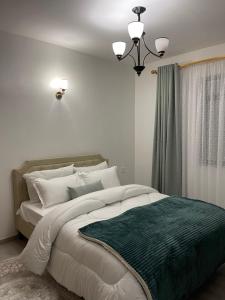 um quarto com uma cama grande e um cobertor verde em Kilimani em Nairobi