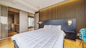 a bedroom with a large bed and a blue wall at Jeju Family Garden Village in Jeju