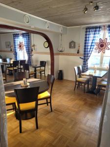 a dining room with tables and chairs and windows at Wärdshuset Klarälvdalen in Sysslebäck