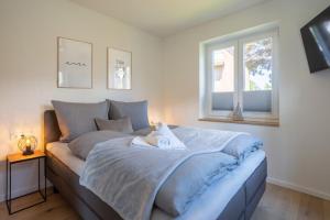 un letto con una coperta blu e una finestra di Villa Dornkamp 2 - Luxuriöse Ferienwohnung für 4 Personen inklusive Garten und Sauna a Timmendorfer Strand