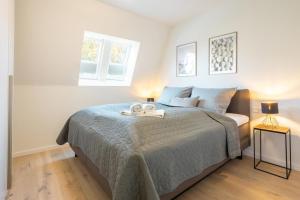 ein Schlafzimmer mit einem Bett mit zwei Handtüchern darauf in der Unterkunft Villa Dornkamp 4 - Luxuriöse Ferienwohnung für 4 Personen inklusive Balkon und Sauna in Timmendorfer Strand