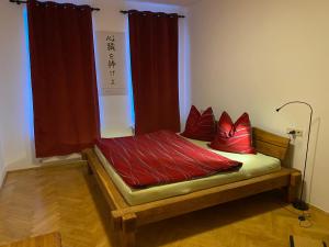 a bed with red pillows on it in a room at Schönes Jugendstil Appartement in bester Lage in Leipzig