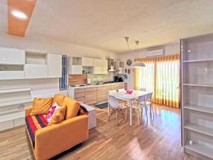 cocina y sala de estar con sofá y mesa en Comodo appartamento Casa Razzoli, en Palau