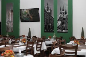a dining room with tables and chairs and green walls at Hotel Alt-Erfurt in Erfurt